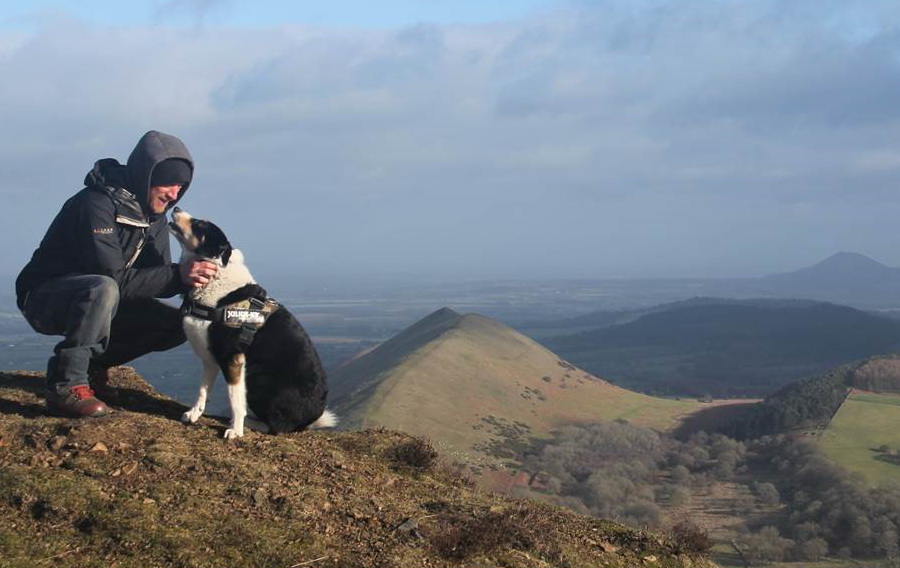 photo of dog and owner on top of hill