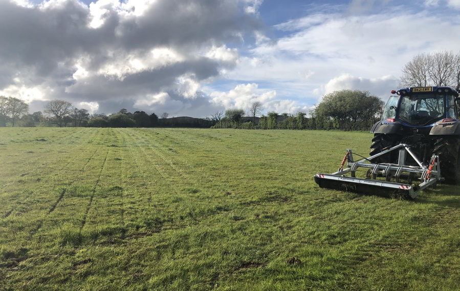 photograph of a tractor aerating grassland